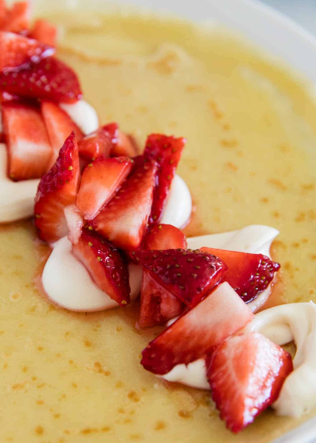 Showing how to make strawberry crepes.