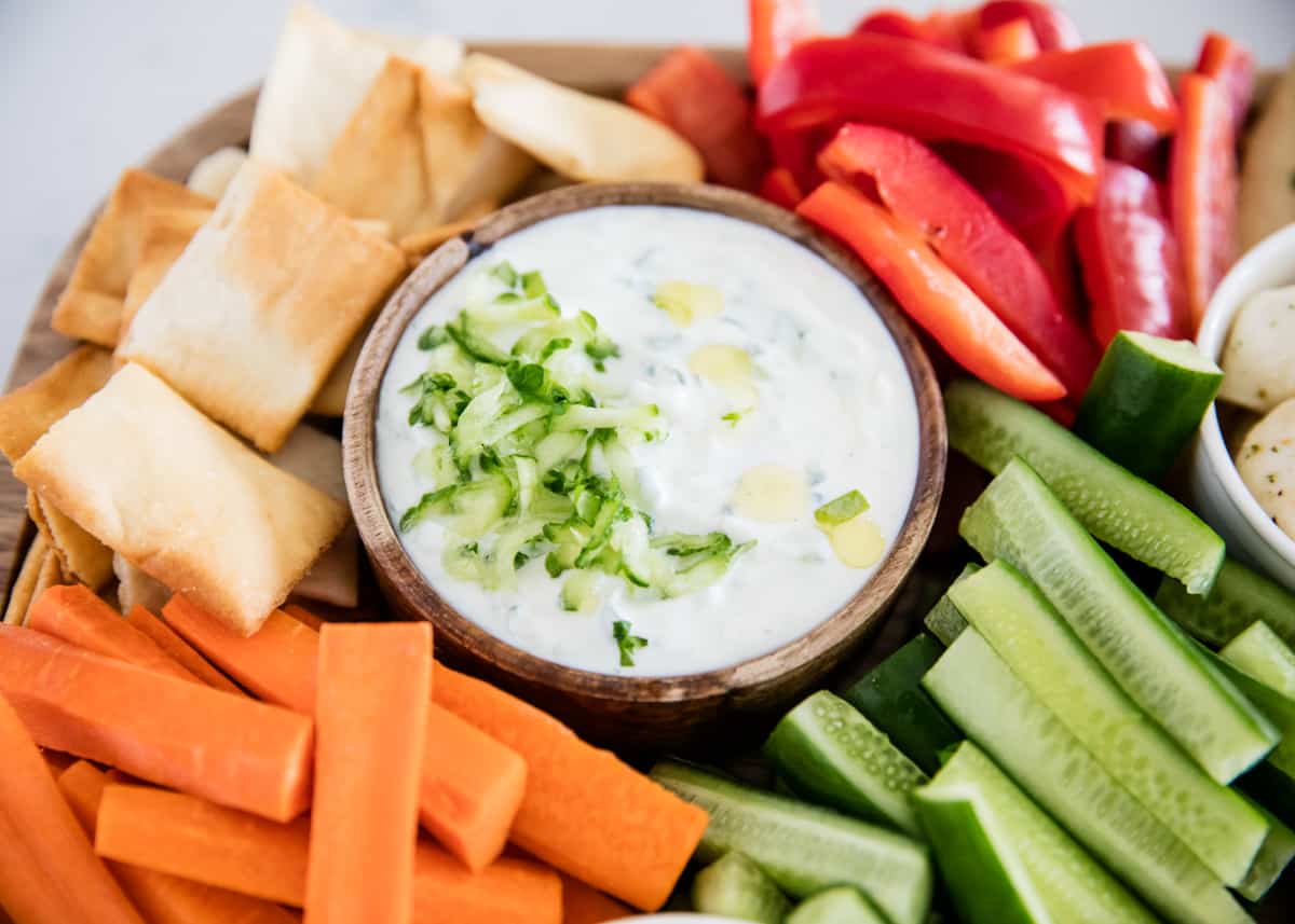 Tzatziki sauce on platter with vegetables.