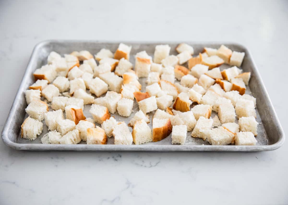 Cubed bread on pan.