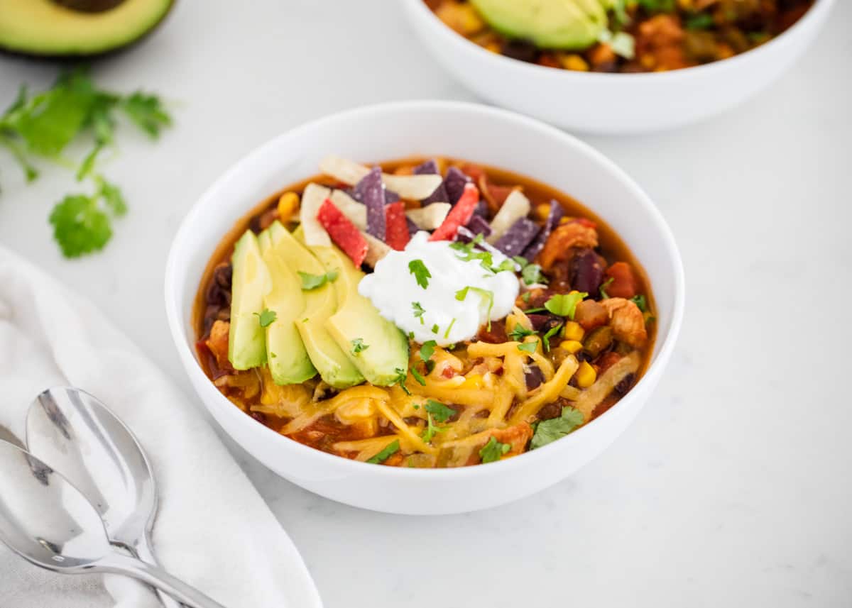 Chicken taco soup in white bowl.