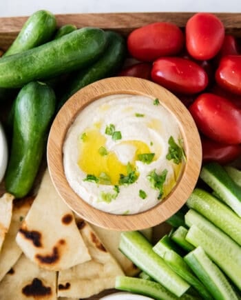 hummus in wooden bowl with vegetables