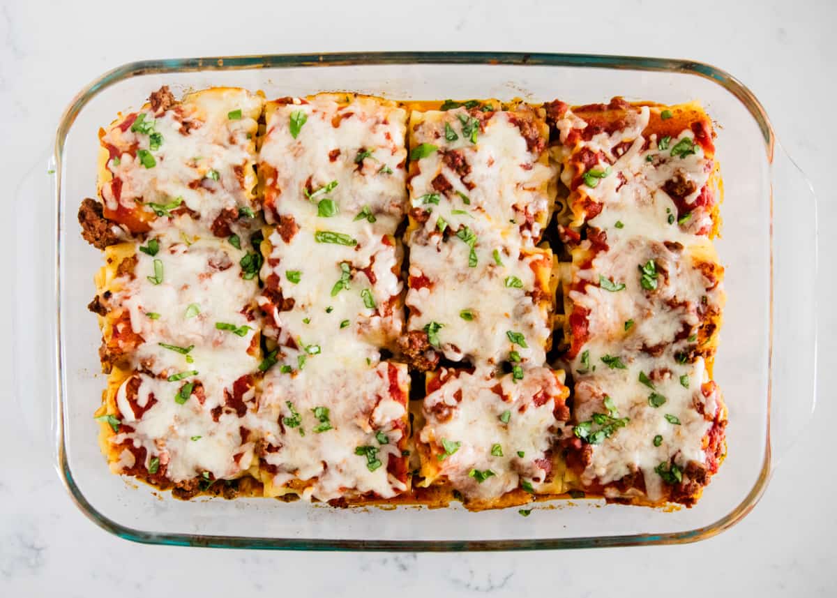 Lasagna rolls in casserole dish.