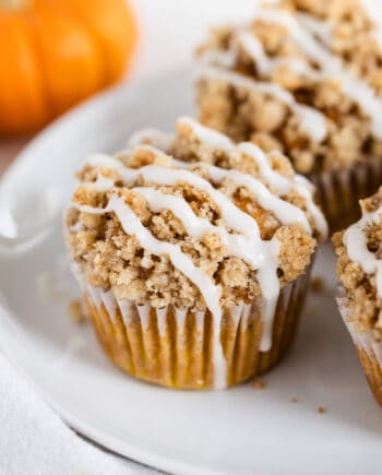 A plate with pumpkin crumb muffins with crumble topping.