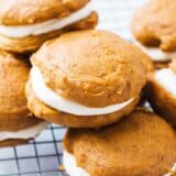 Pumpkin whoopie pies on a cooling rack.