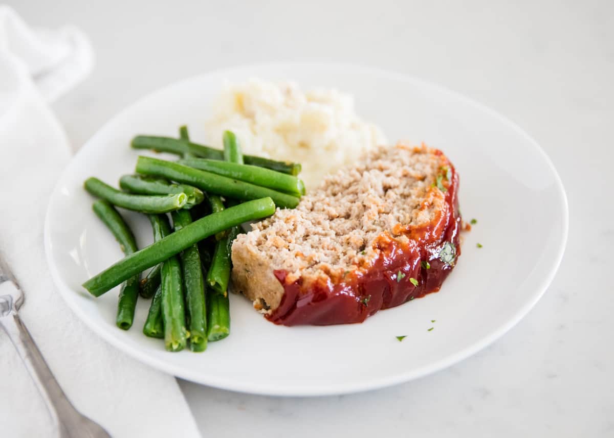 Turkey meatloaf with green beans on plate.