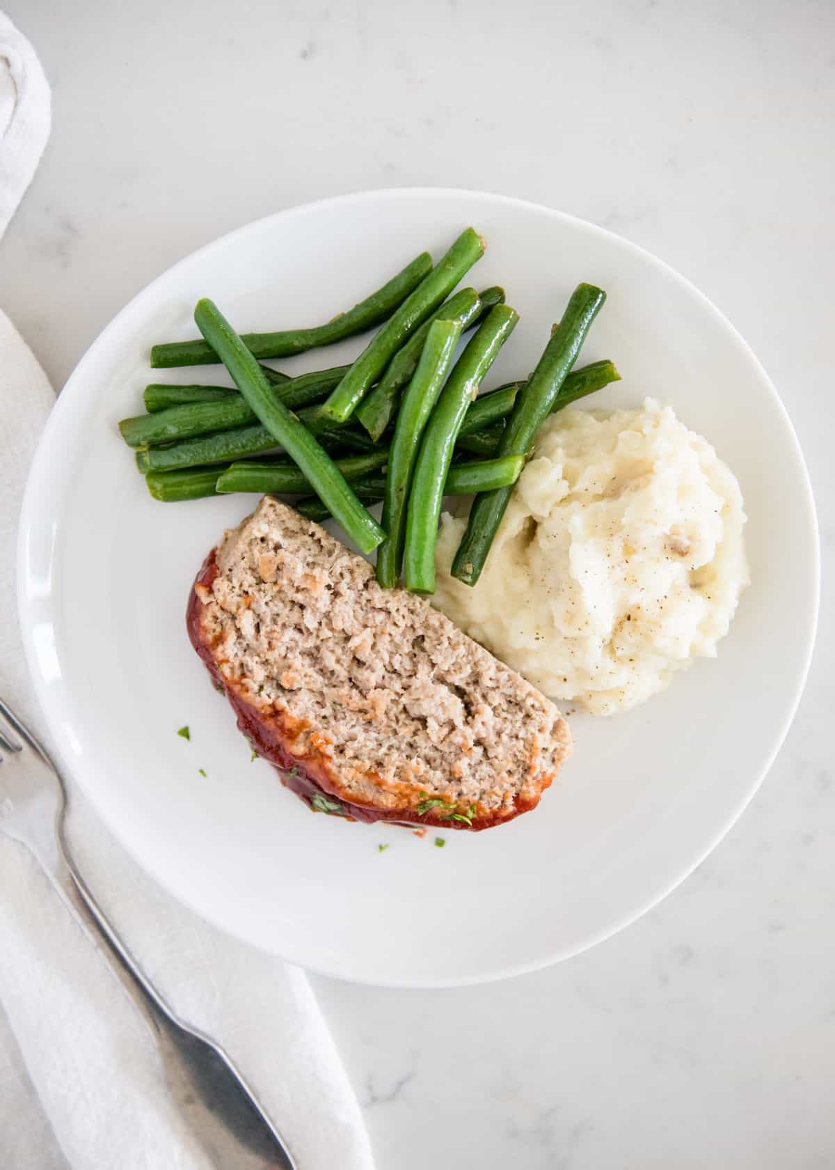 Turkey meatloaf dinner on white plate.