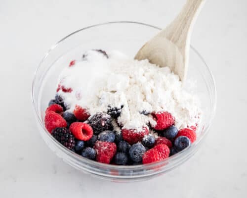mixed berries with flour in glass bowl
