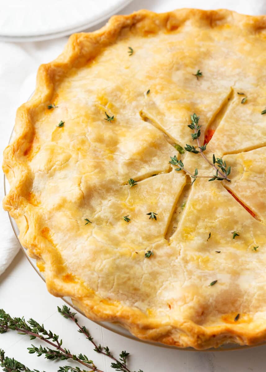 Homemade chicken pot pie with thyme on counter. 