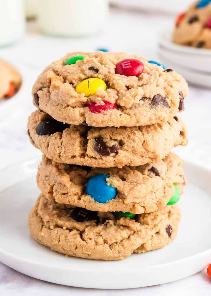 Stack of peanut butter m&m cookies on a white plate. 