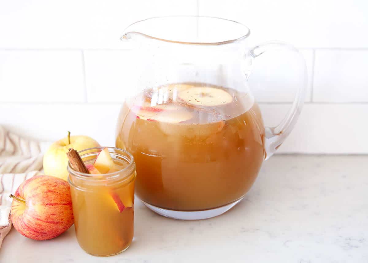 Pitcher full of Thanksgiving punch with a cup.