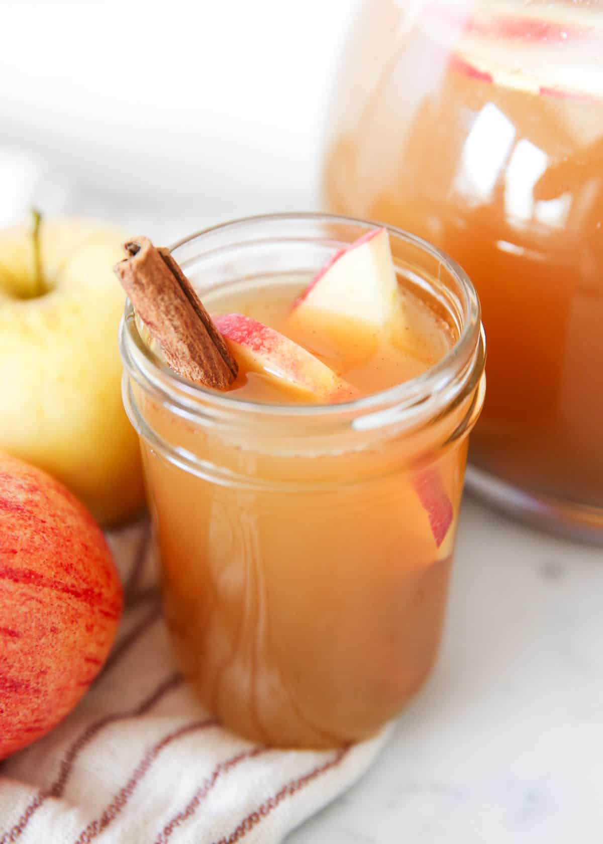 A mason jar cup filled with Thanksgiving cider punch.