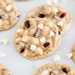 Soft and chewy white chocolate cranberry cookies studded with white chocolate chips and dried cranberries on a baking sheet.