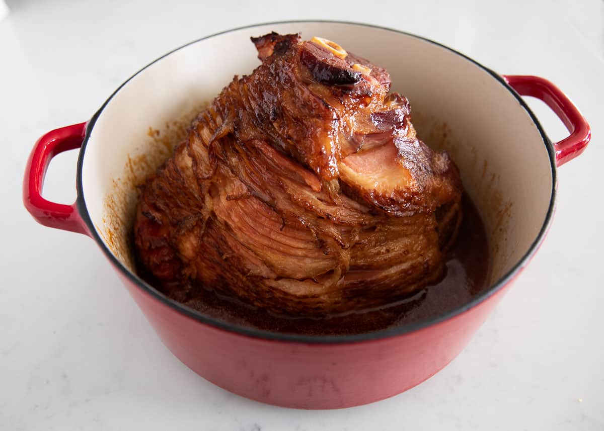 Sliced ham in red pot.