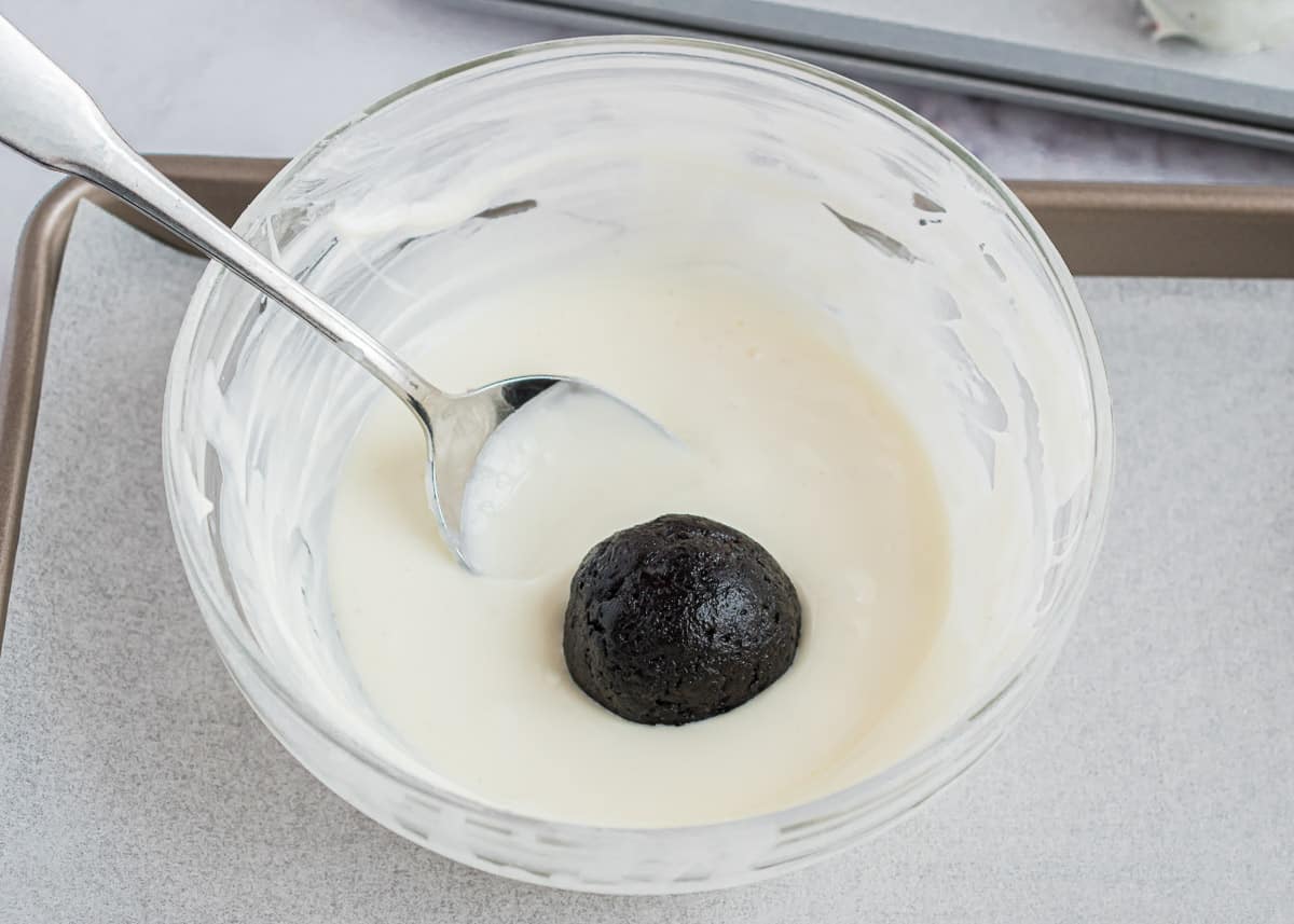 Dipping oreo balls in white chocolate.