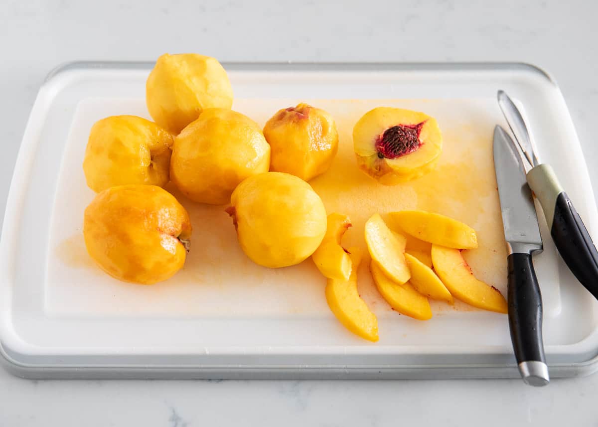 Slicing peaches on cutting board.
