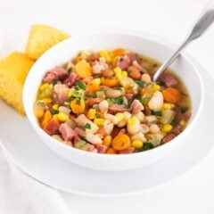 Ham and bean soup made with canned beans in a bowl with cornbread on the side.