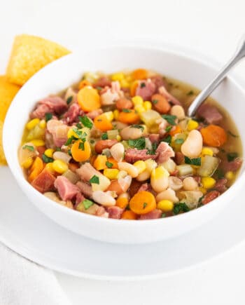 Ham and bean soup made with canned beans in a bowl with cornbread on the side.