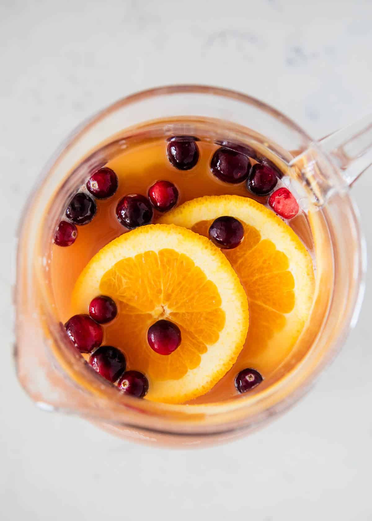Holiday punch in pitcher with orange slices.