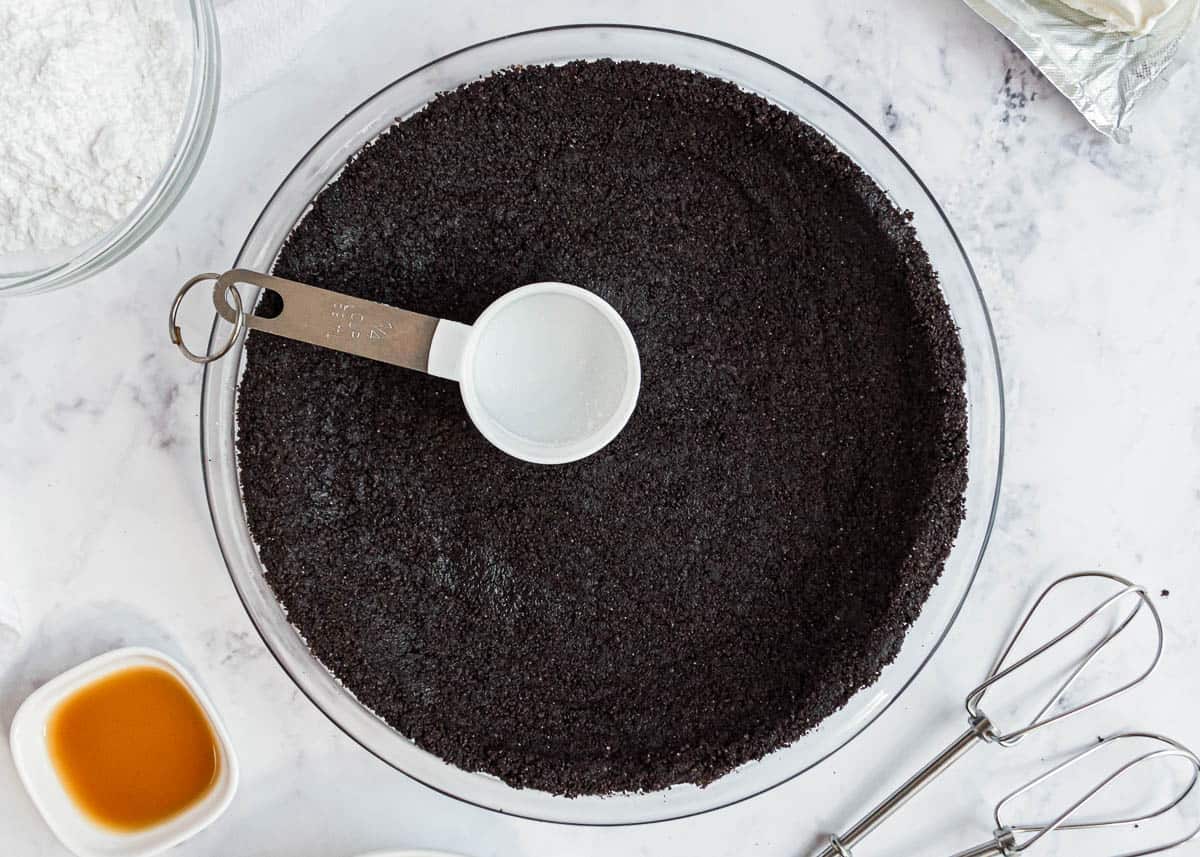 Pressing a oreo crust into a pie dish.