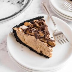 Slice of Oreo peanut butter pie on a plate with a fork.
