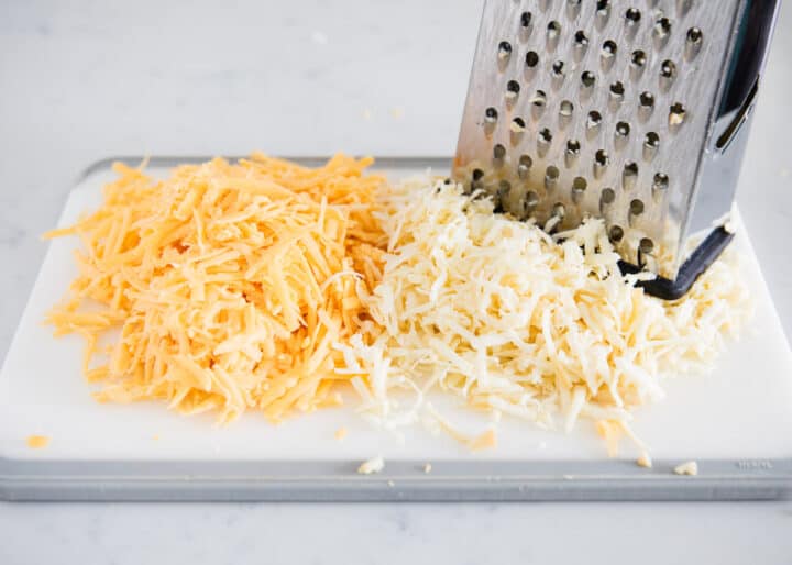 shredding cheese on cutting board