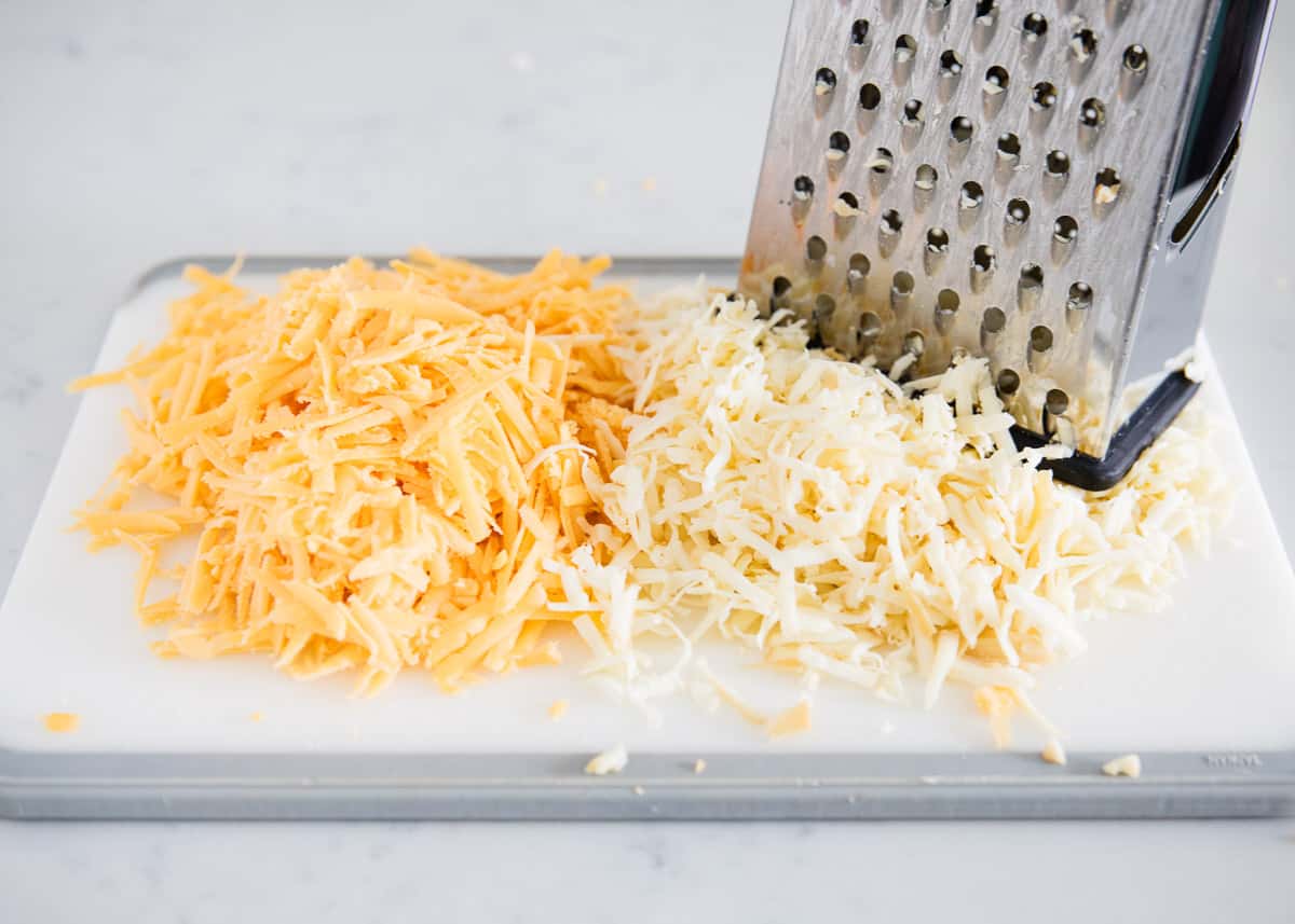 Shredding cheese on cutting board.