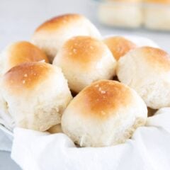 Soft, fluffy homemade dinner rolls recipe in a basket.