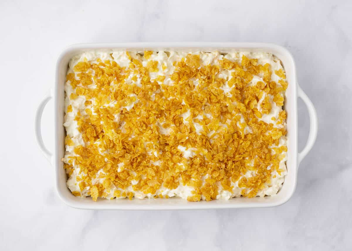 Showing how to make cheesy potatoes in a casserole dish.