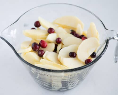 apple and cranberries in glass bowl