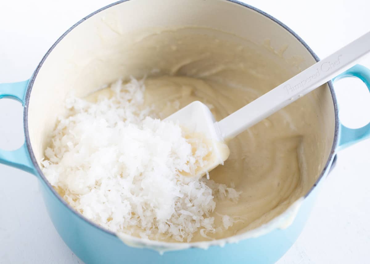 Mixing coconut into pot.