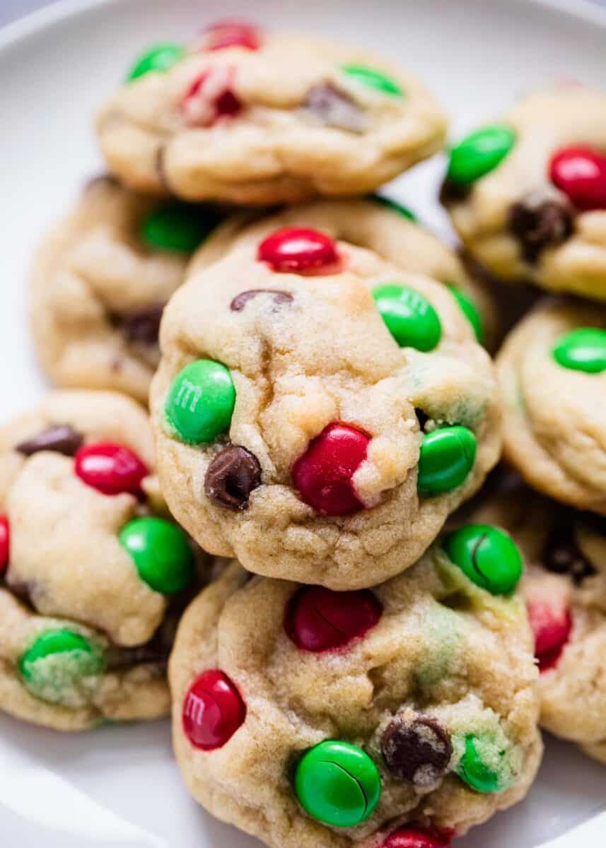 Thick and chewy M&M Christmas cookies with crispy edges, a soft center and bursting with chocolate flavor. These are the ultimate cookie recipe to make this holiday season! The best M&M Christmas Cookies on a plate.