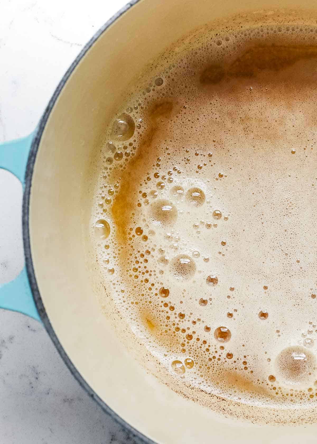 Close up of foamy brown butter in pan.