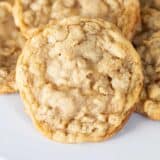 Oatmeal cookies stacked on a white plate.