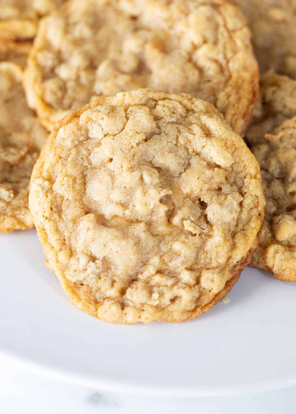 Oatmeal cookies stacked on a white plate.