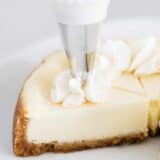 piping whipped cream on cheesecake