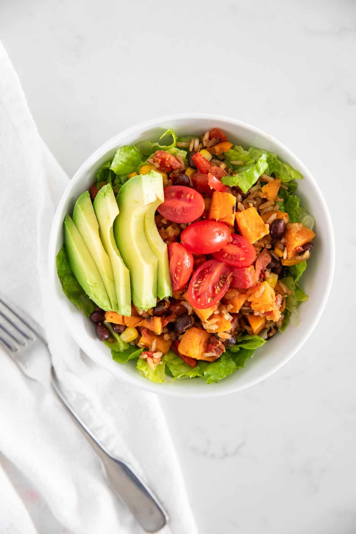 These one pot sweet potato bowls are an easy vegetarian meal option that's ready in just 30 minutes! Loaded with diced sweet potatoes, black beans, corn, rice and seasonings, this delicious dinner packs a punch of flavor. Sweet potato bowls on table.