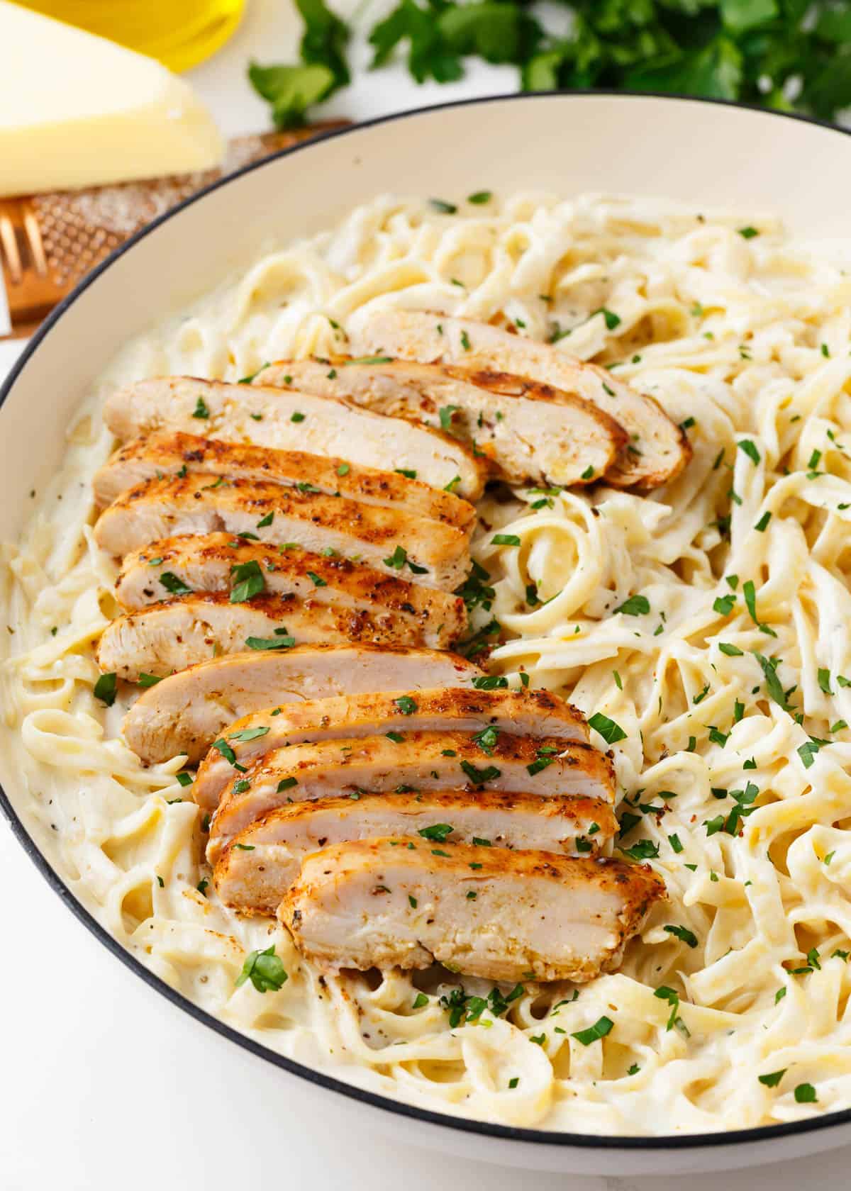 Chicken alfredo in a bowl with fettuccini noodles.