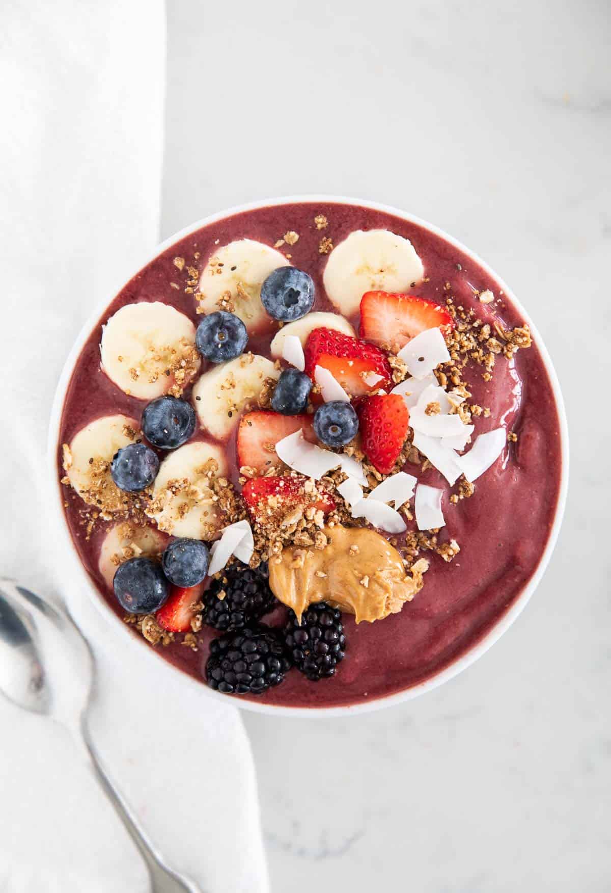 Acai smoothie in bowl with fruit and toppings.