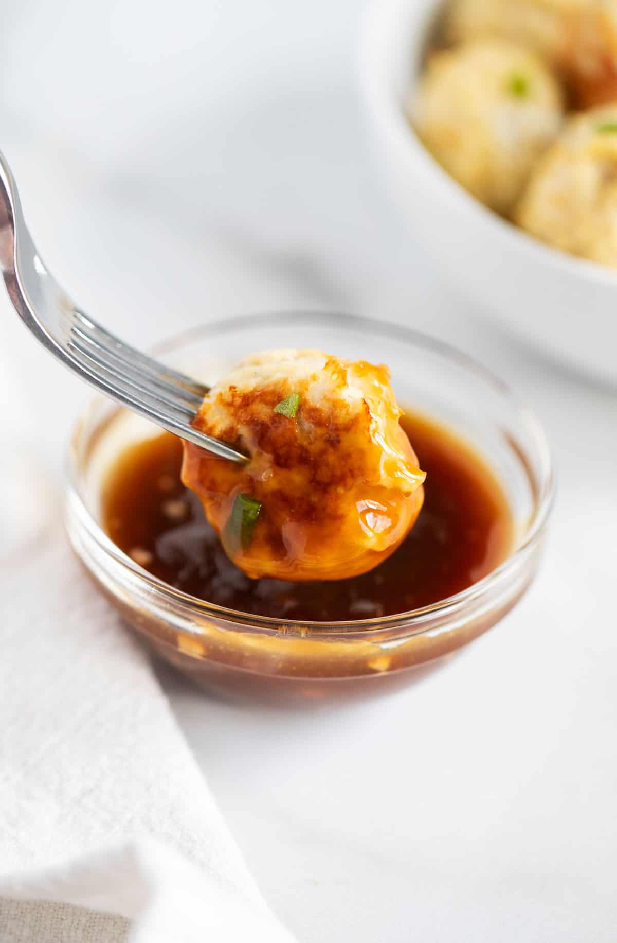 Chicken meatball dipped in sauce.