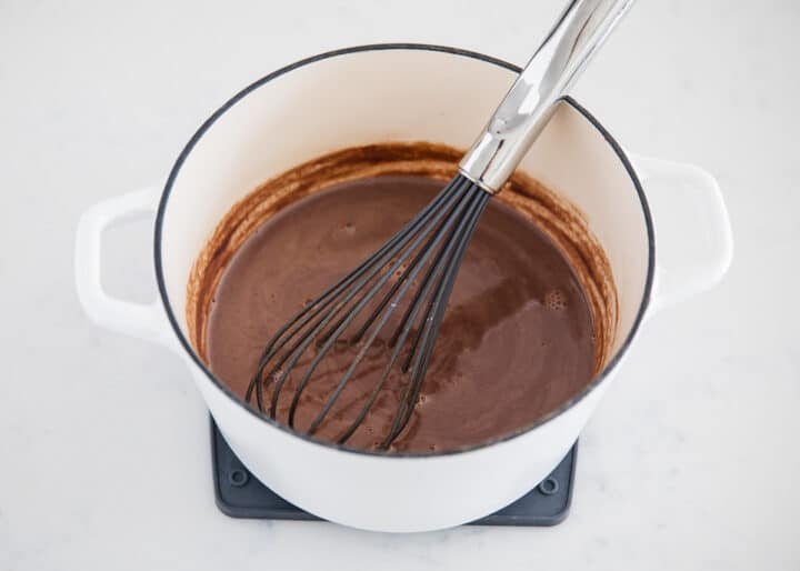 A rich and creamy homemade hot chocolate that tastes heavenly on a cold winter day. Only takes 5 ingredients and 10 minutes to make! whisking hot chocolate in pot