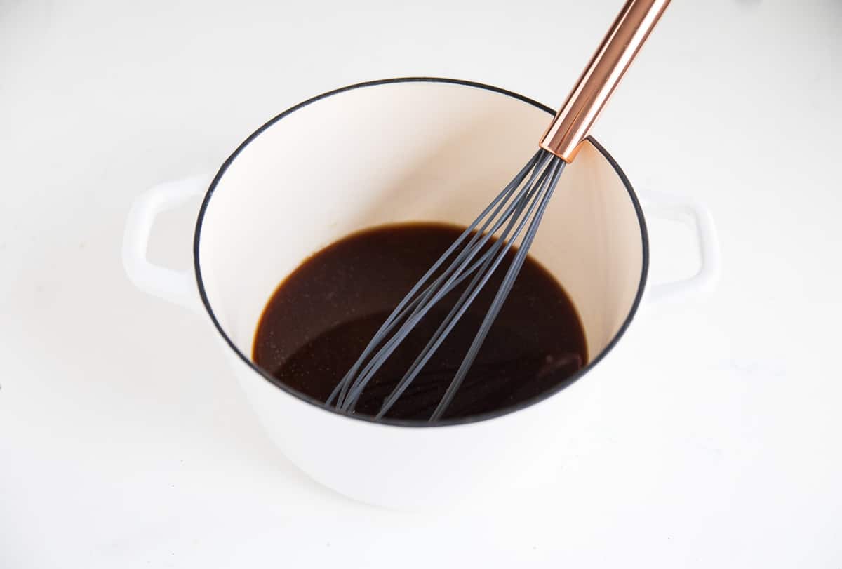 Teriyaki sauce in pan with whisk.