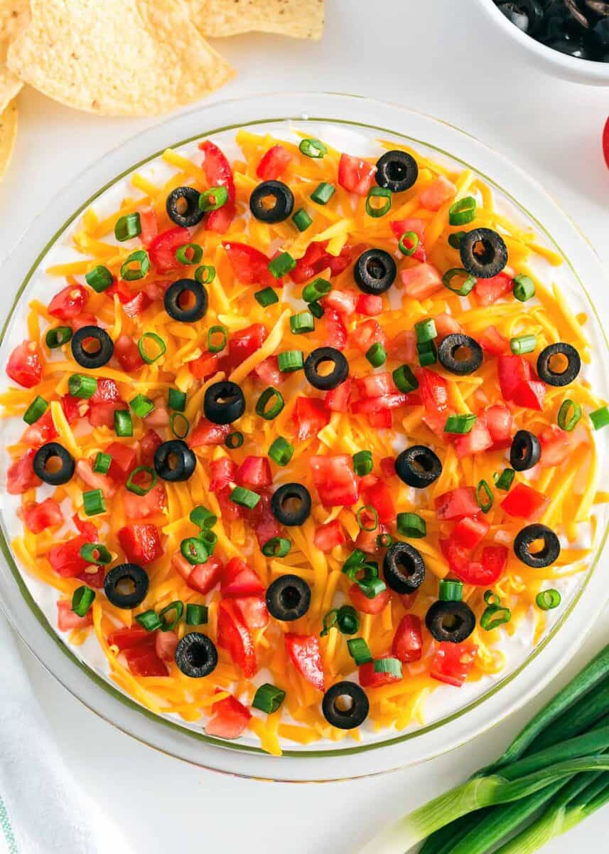 5 layer dip in a glass dish with toppings.