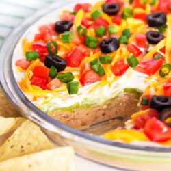 5 layer dip with tortilla chips on counter.