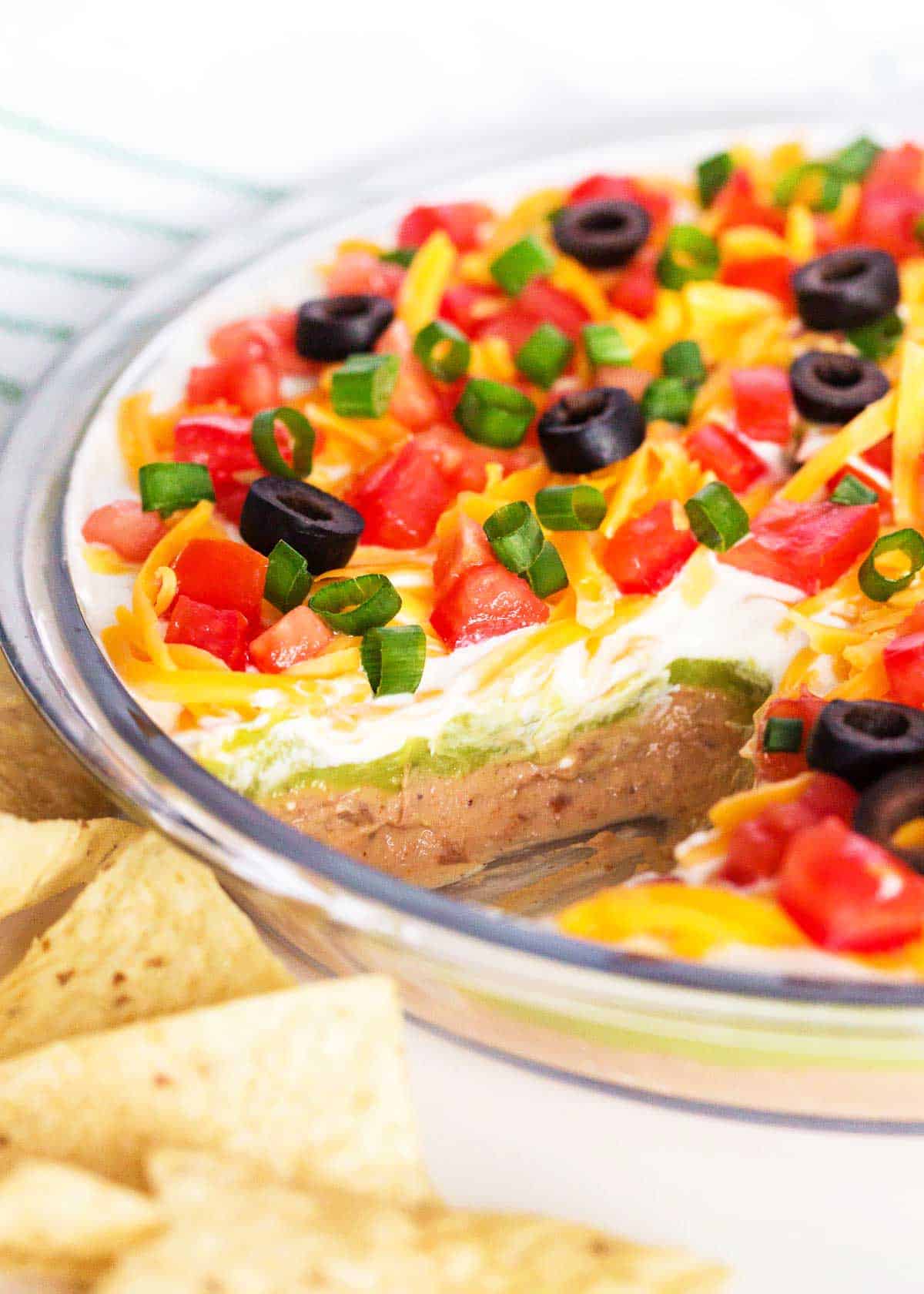 5 layer dip with tortilla chips on counter.