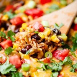 Wooden spoon getting some burrito bowl out of pot.