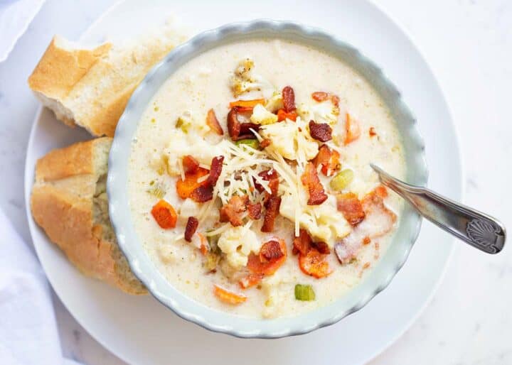 cauliflower soup with bread on white plate