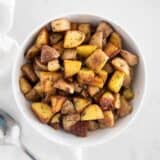 cast iron skillet potatoes in white bowl