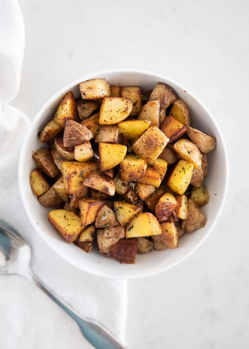 cast iron skillet potatoes in white bowl