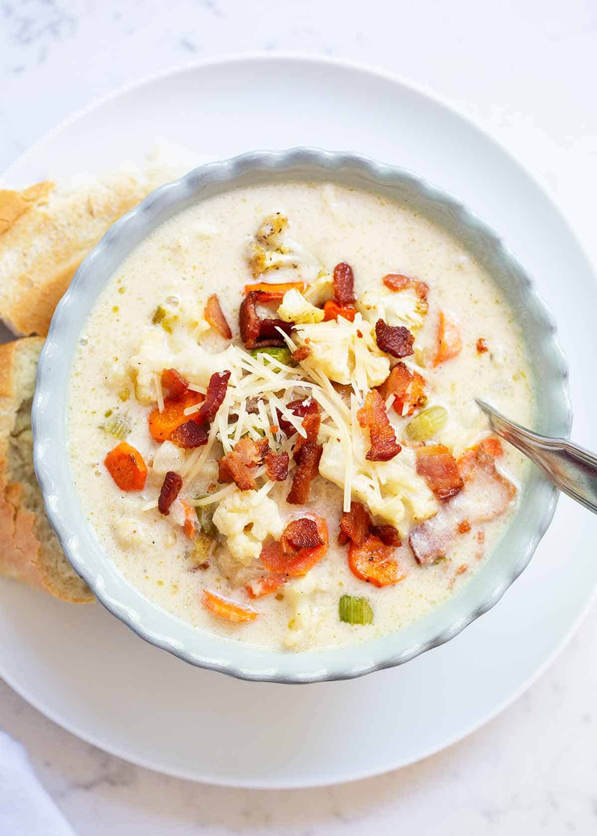 Cauliflower soup with bread on plate.
