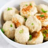 Close-up of baked chicken meatballs garnished with green onions.
